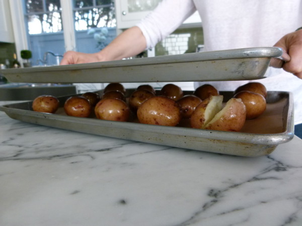 put another baking sheet on top to flatten potatoes