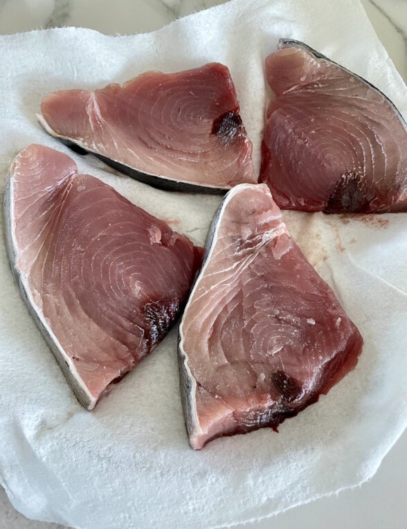 raw tuna steaks on a paper towel