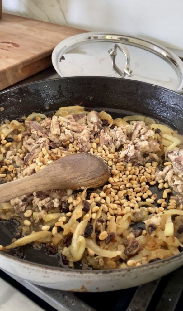 a pan with sauteed ingredients and a wooden spoon 