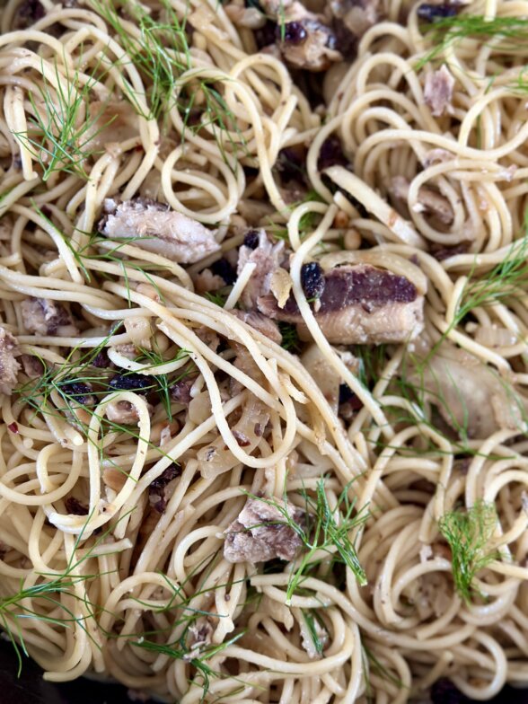 a close up photos showing sardines mixed with pasta noodles