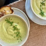 bowls of broccoli soup with bread