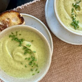 bowls of broccoli soup with bread