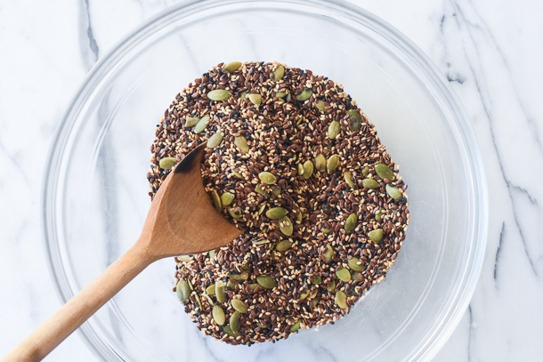 seeds in a glass bowl with a wooden spoon 