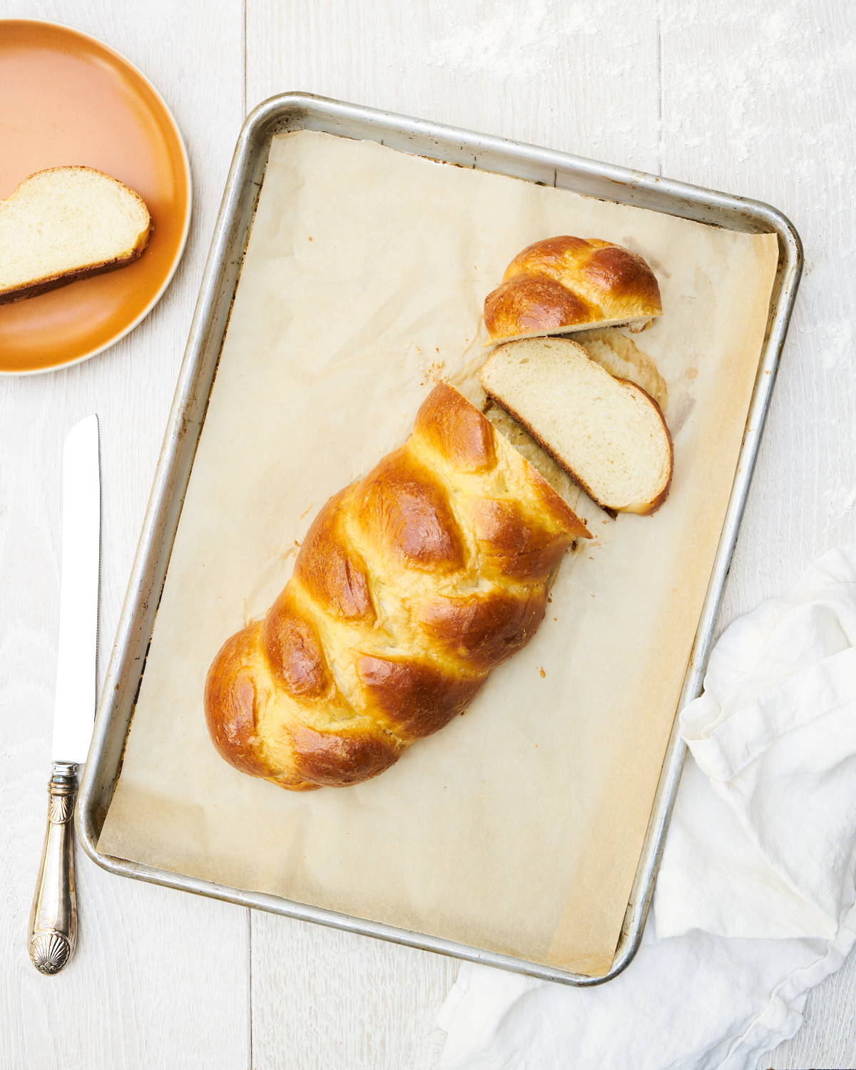 Sliced challah loaf on a baking sheet