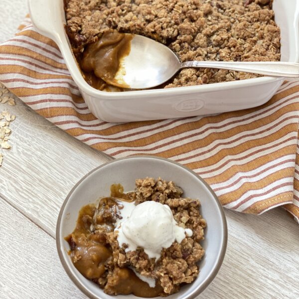 a bowl of pumpkin crisp with a scoop of vanilla ice cream on top