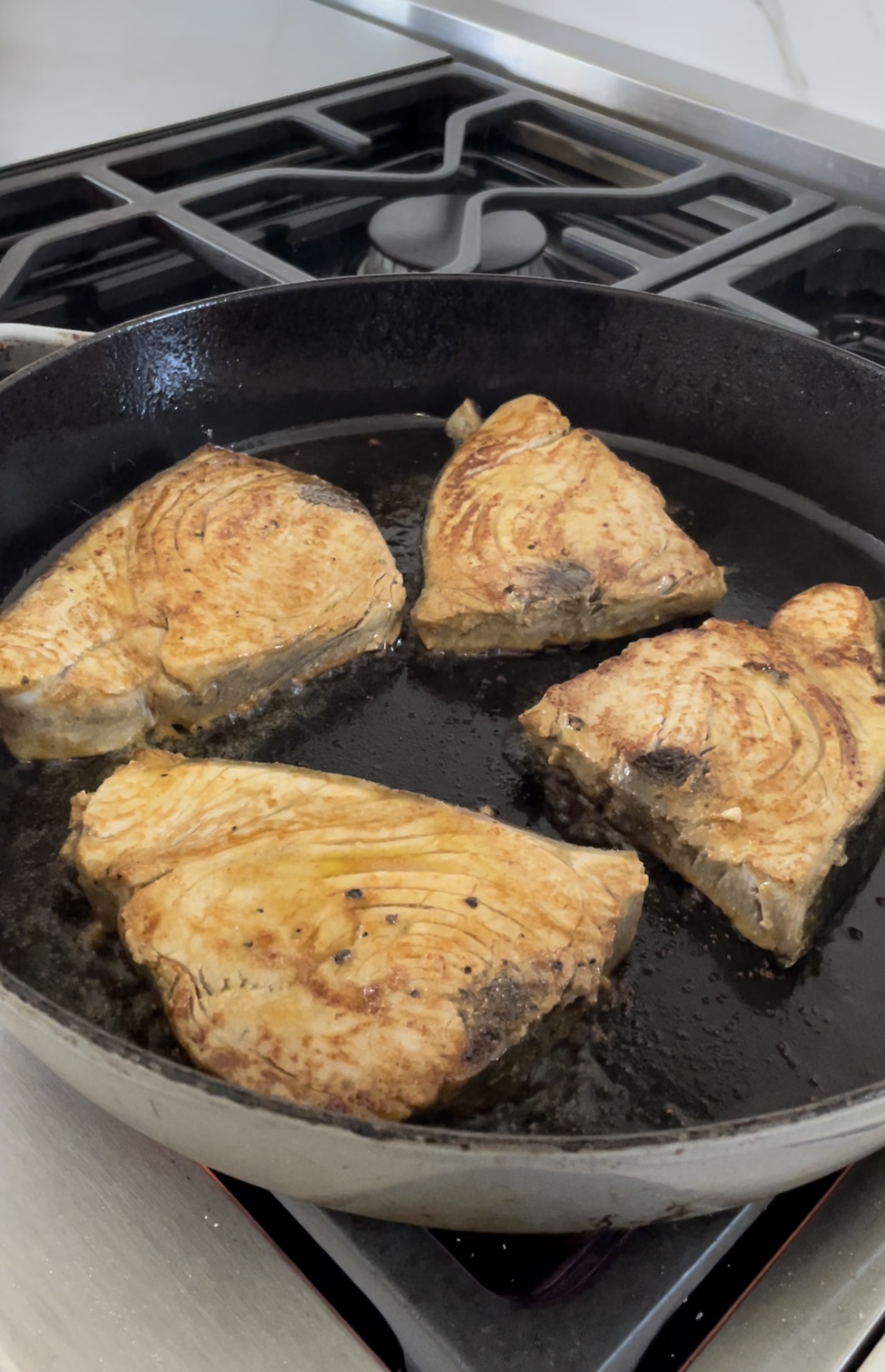 searing fish in a cast iron pan