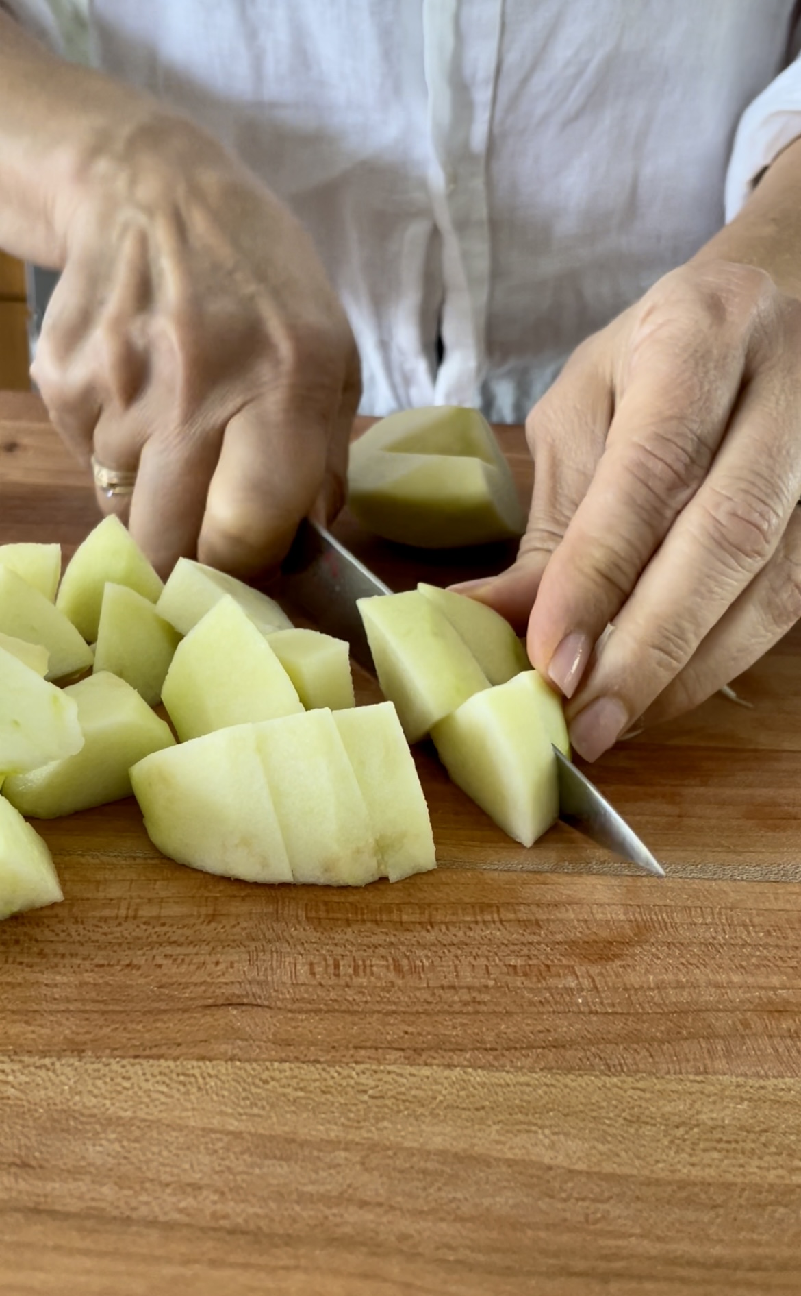 hands cutting apples on a cutting board 