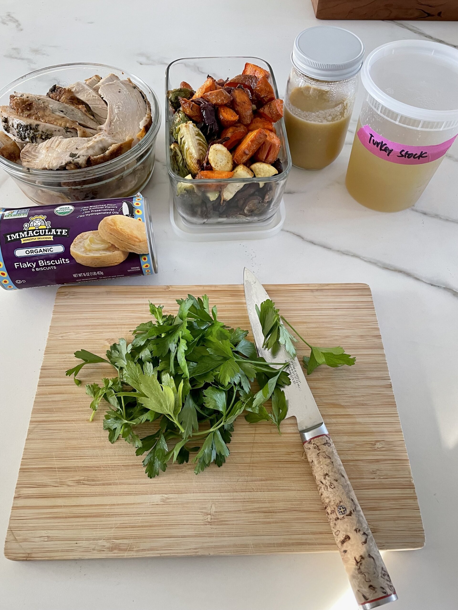 ingredients in containers, fresh parsley on a cutting board with a knife