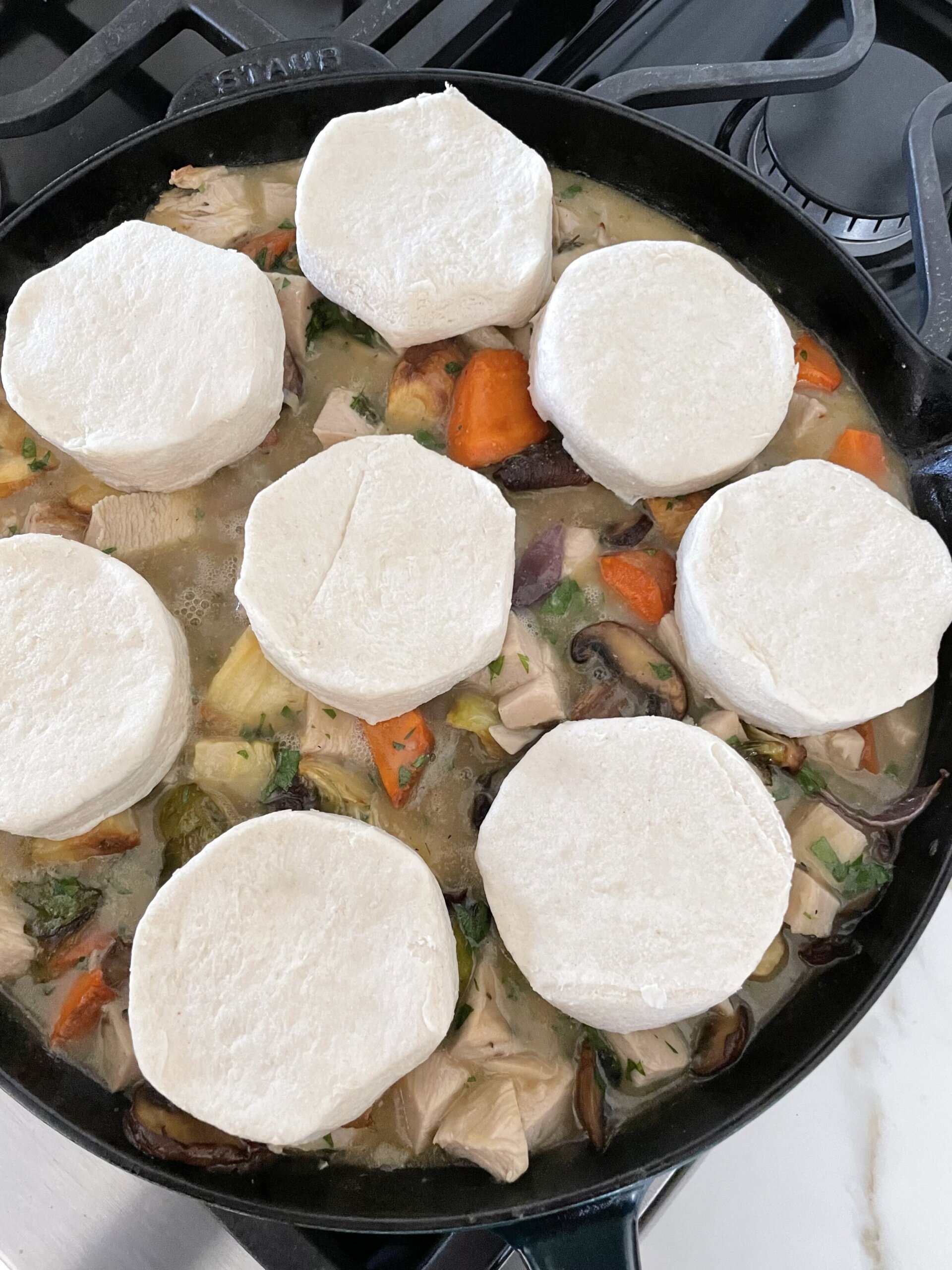 biscuits on top of pit pie filling in a skillet