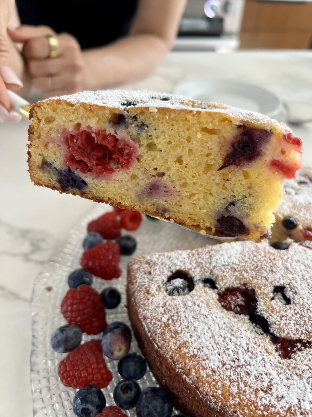 a hand serving a slice of cake