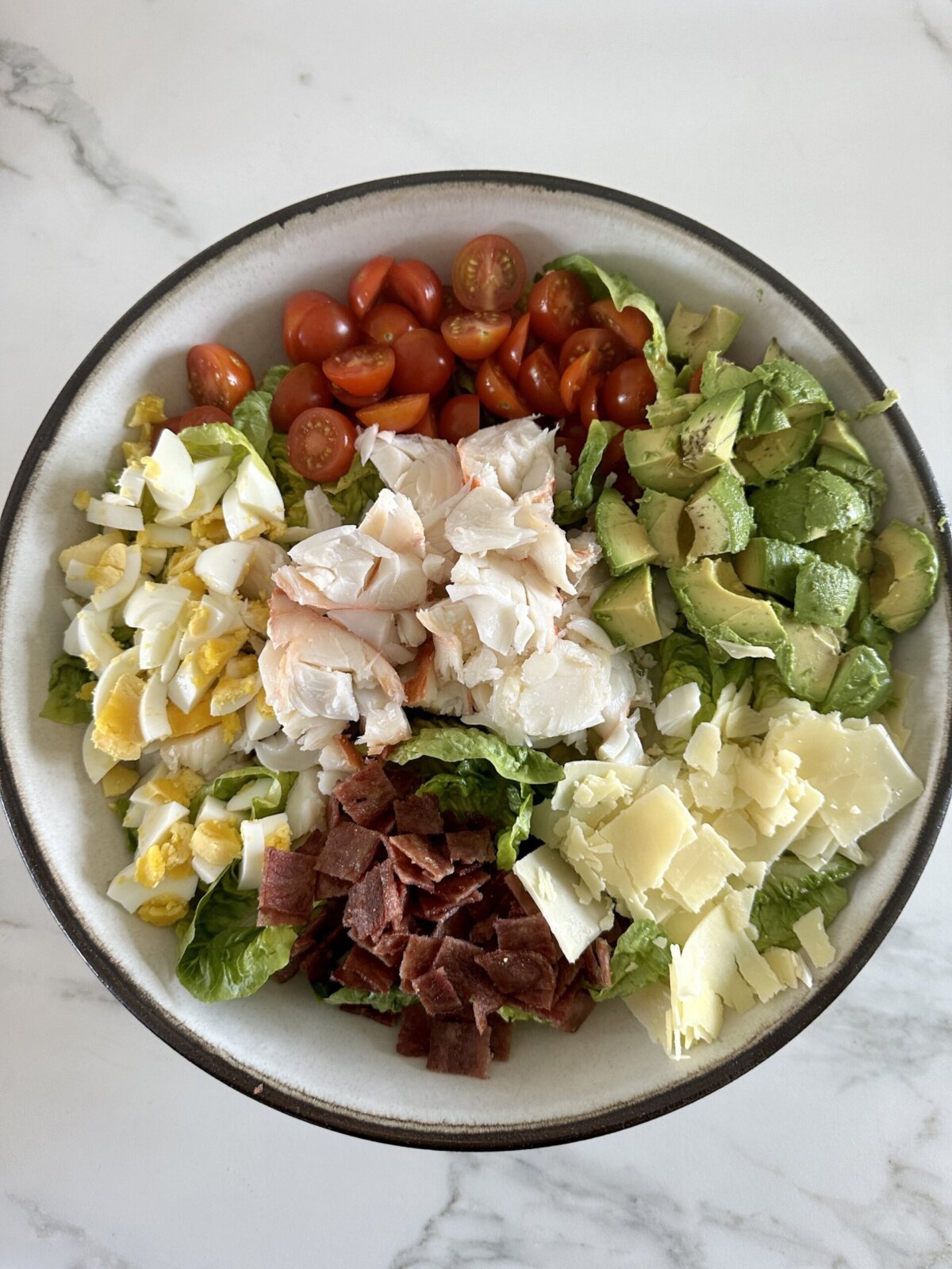 an overhead photo of lobster cobb salad in a bowl 