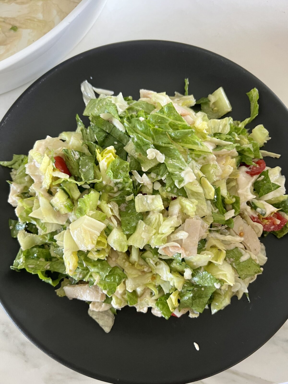 an Italian chopped salad on a black plate