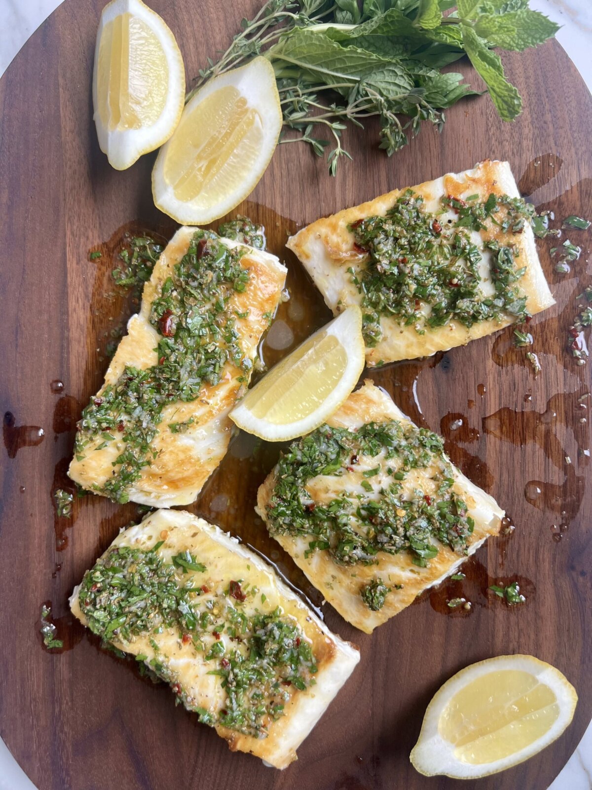 an overhead shot of fish topped with salmoriglio sauce