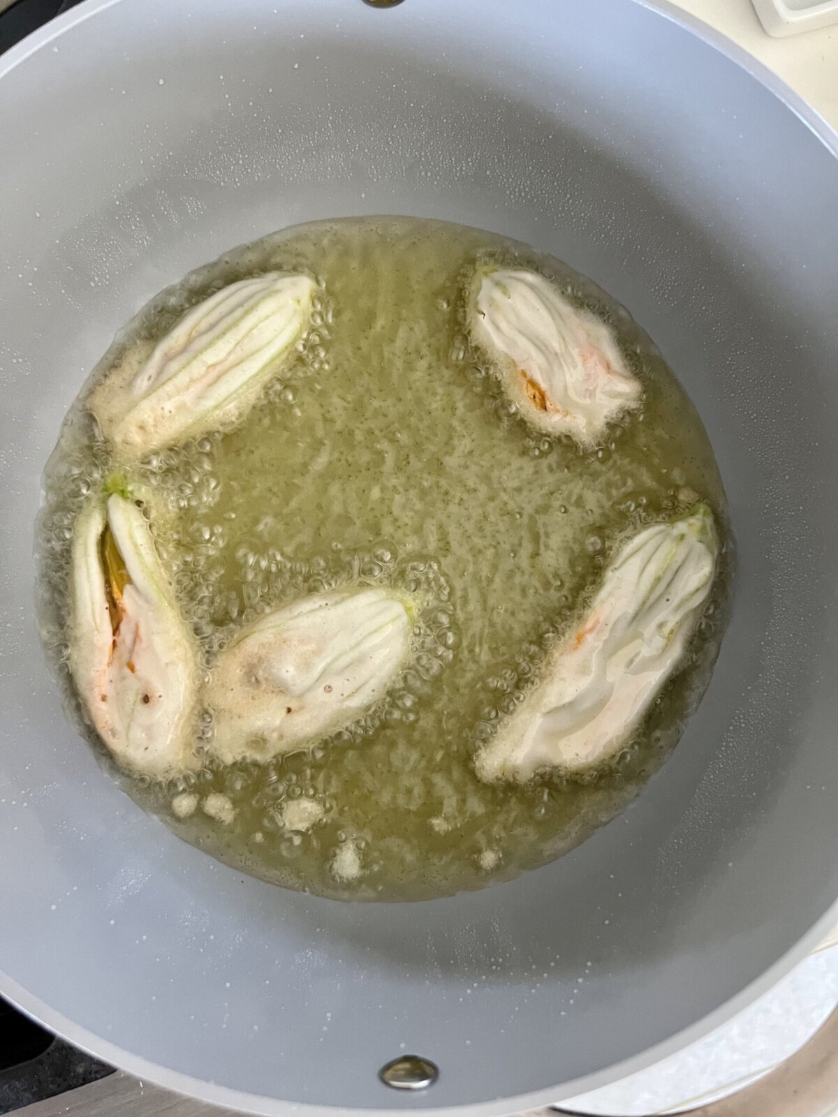 zucchini blossoms frying in oil