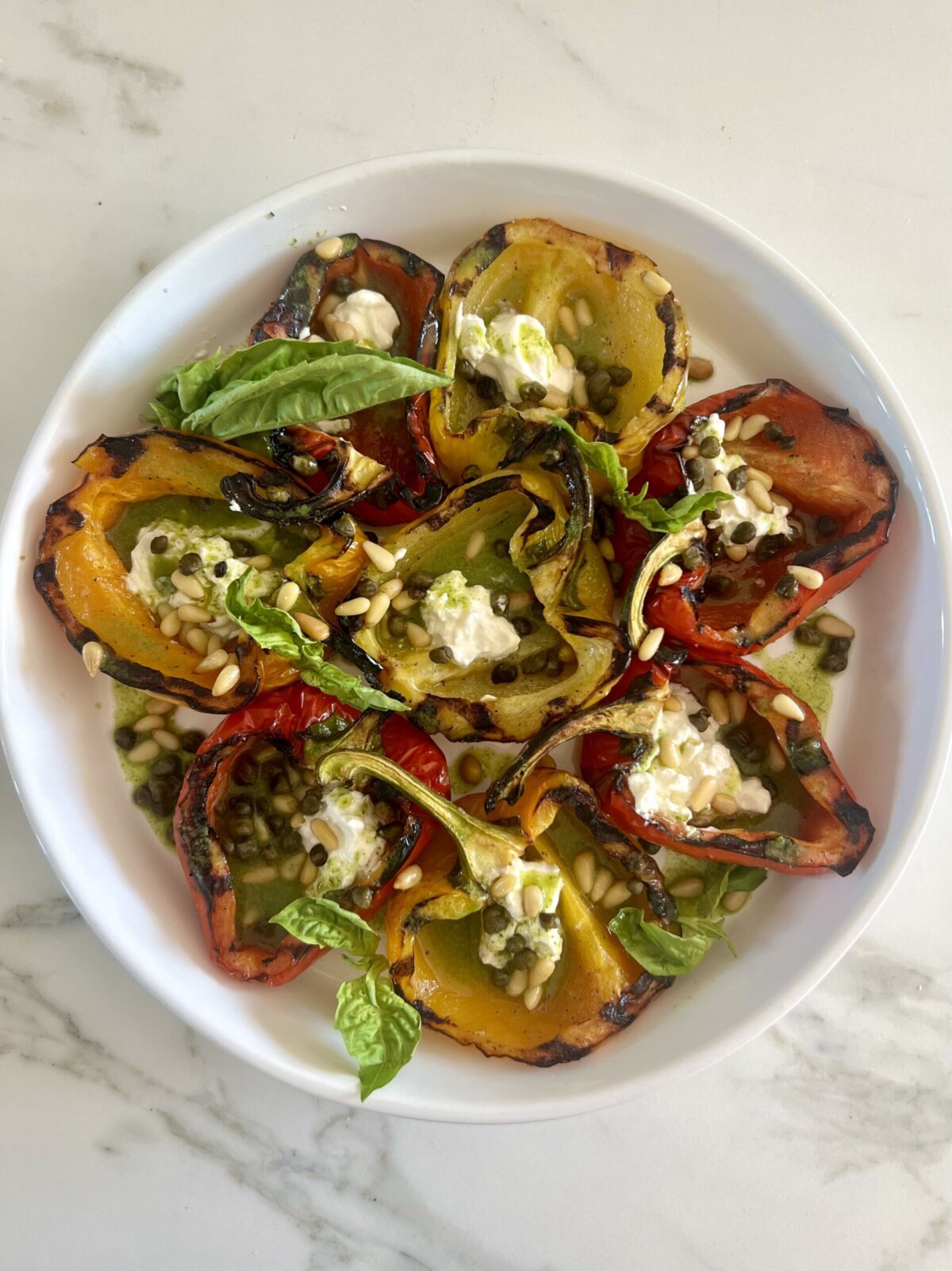 an overhead shot of grilled bell peppers on a white platter