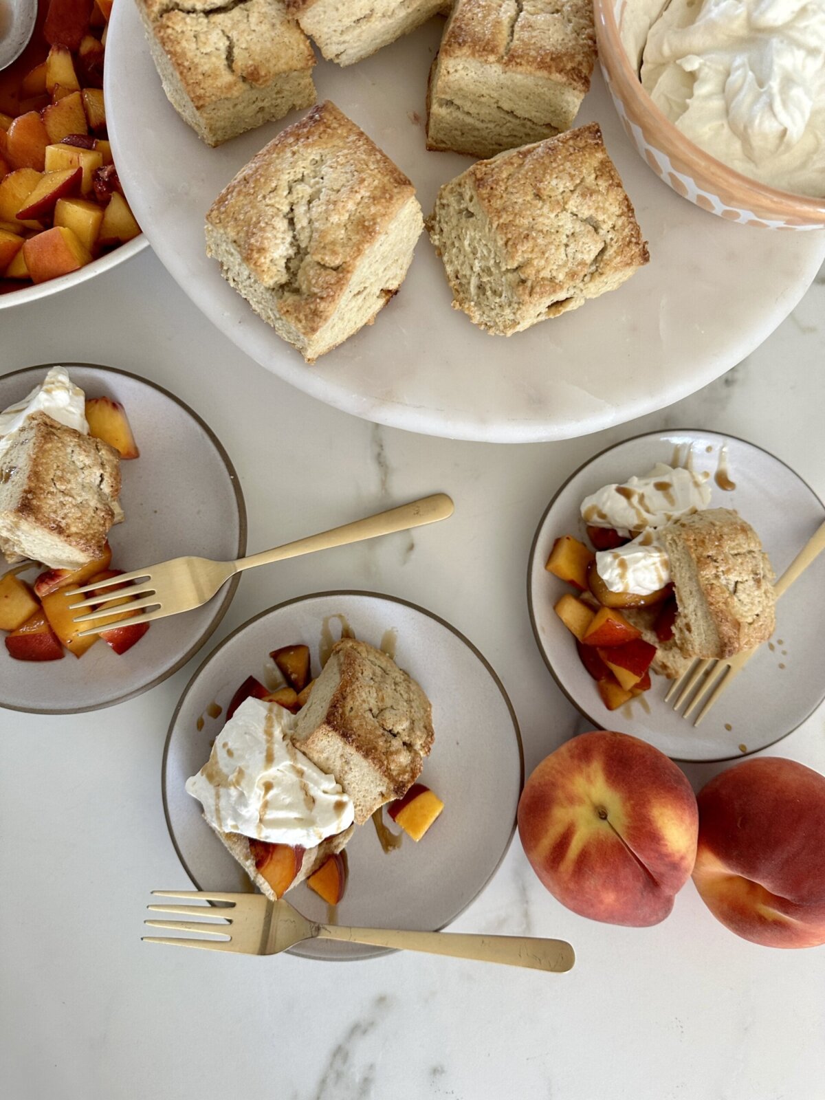 an overhead shot of three plates of peach shortcakes