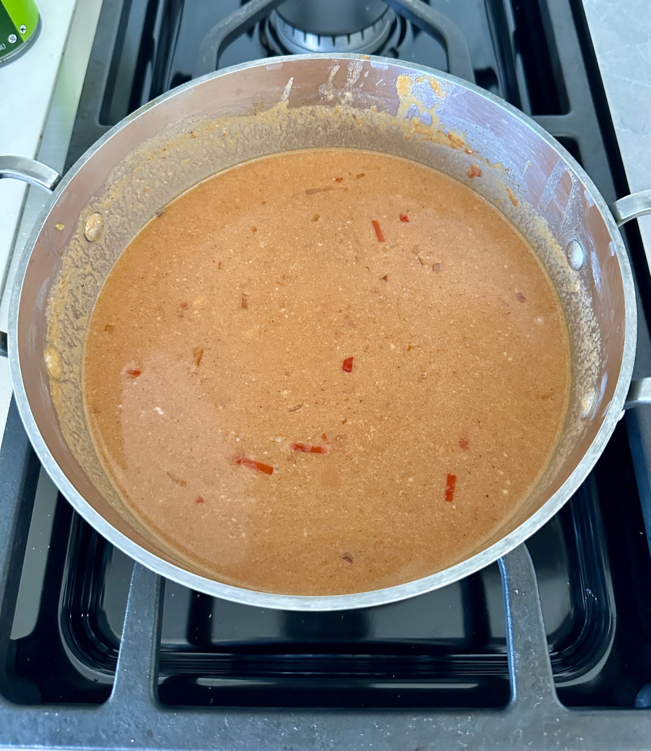 a skillet on the stovetop with coconut tomato sauce