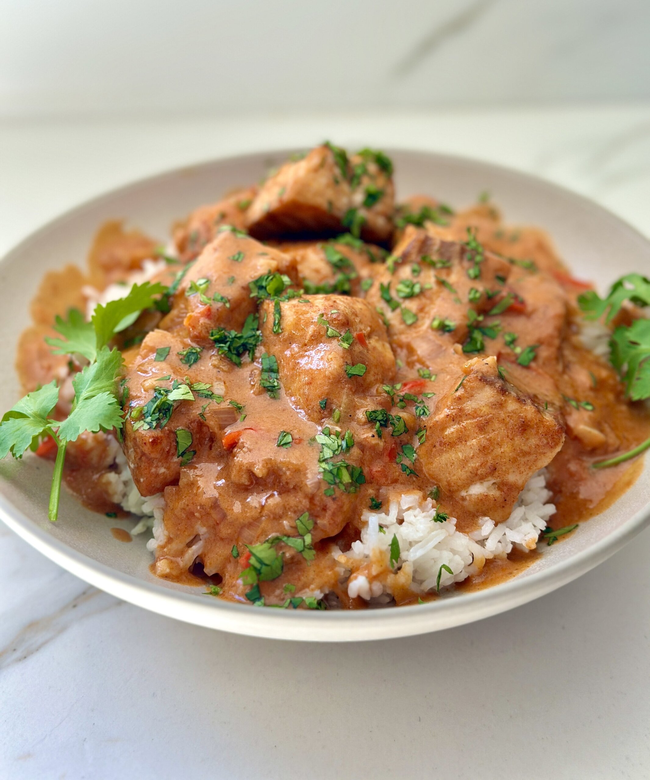 a serving platter filled with oven roasted salmon, rice, and coconut tomato sauce