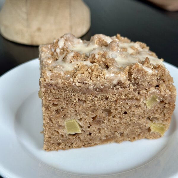 a slice of applesauce coffee cake on a white plate.