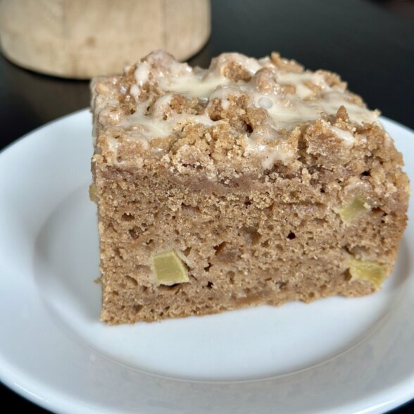 a slice of applesauce coffee cake on a white plate.