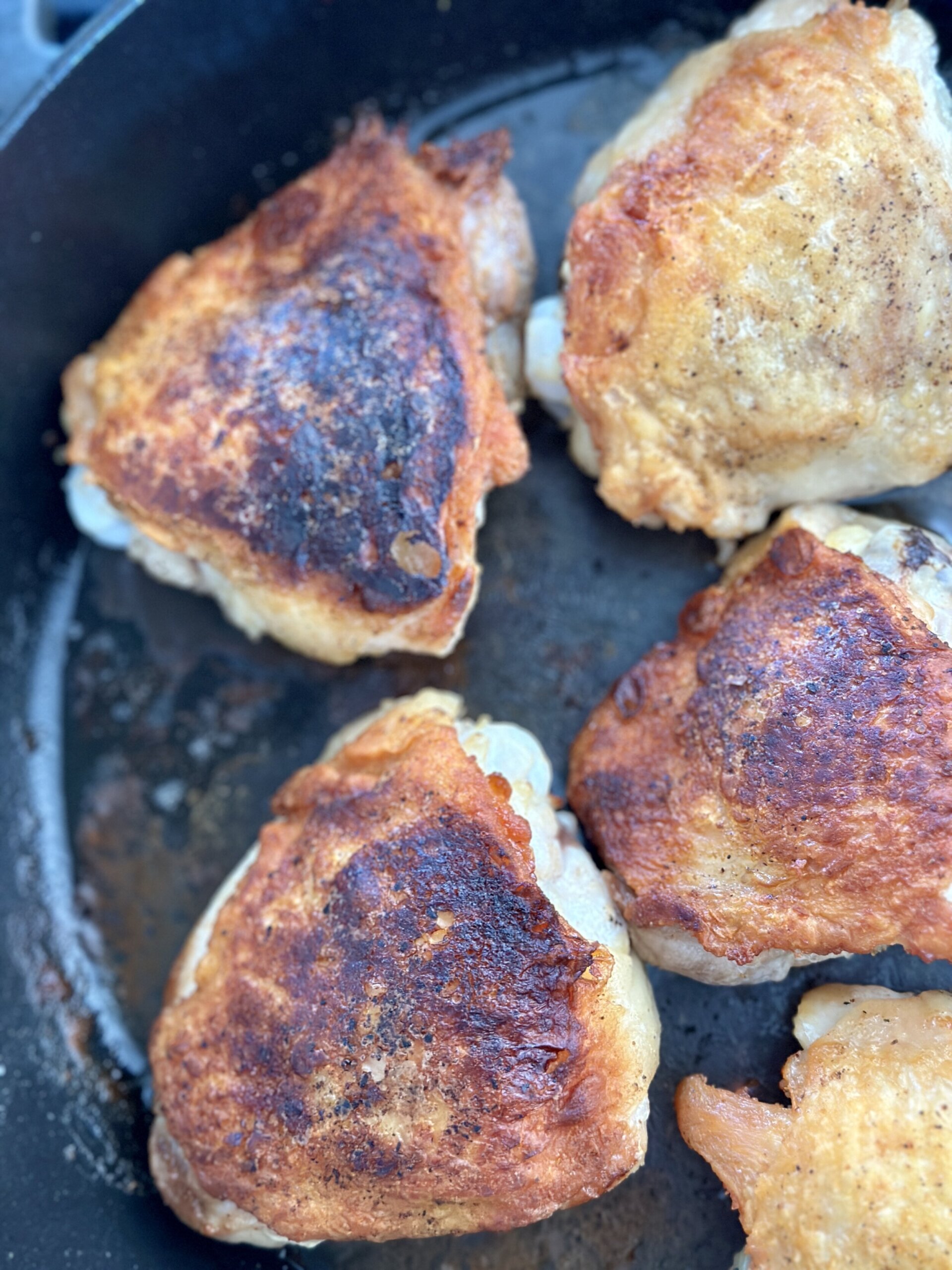 chicken in a skillet with browned crispy skin