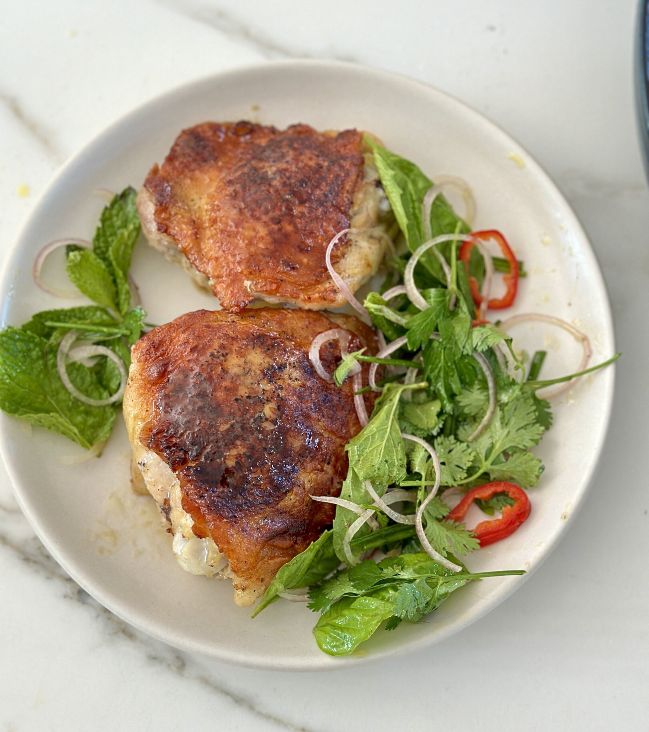 Crispy chicken things on white plate with herbs