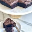 gluten-free vegan chocolate cake with sweet potato frosting on a stand and a plate with a fork