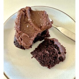 a slice of gluten-free vegan chocolate cake with sweet potato frosting on plate