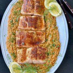 salmon over red split lentils on a white serving platter