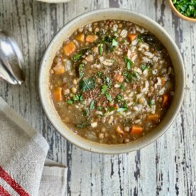 bowl of lentil and brown rice soup on a wooden table