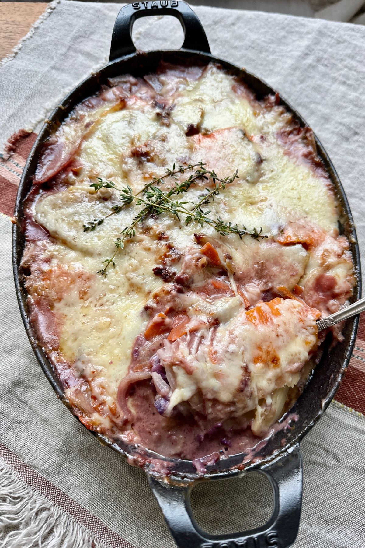 root vegetable gratin in a baking dish topped with cheese