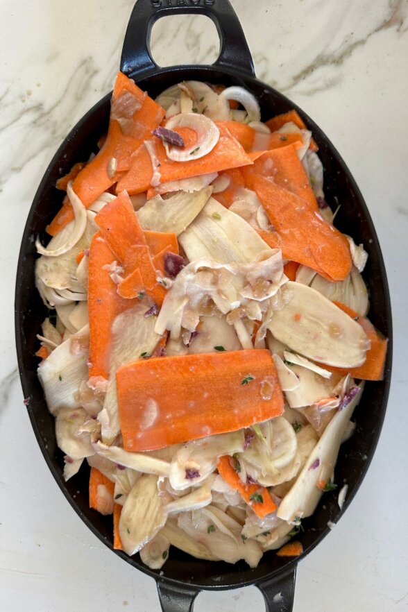 sliced root veggies in a baking dish 