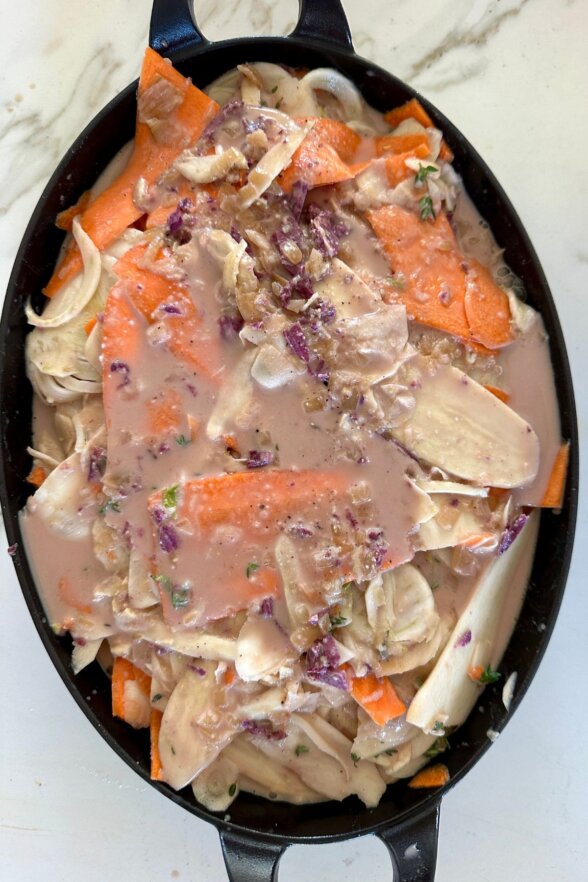 a baking dish filled with root veggies and a cream sauce 