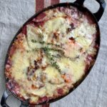 root vegetable gratin in a baking dish and topped with fresh thyme