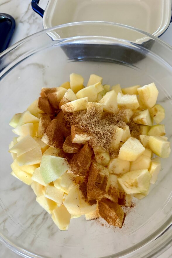 cut apples in a bowl topped with cinnamon and sugar