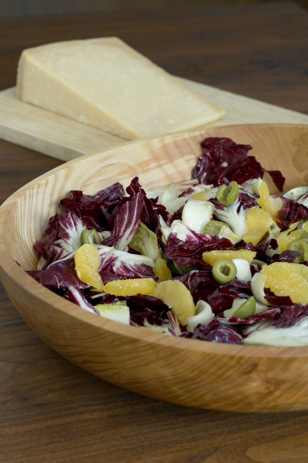 bowl of salad with parmesan block in the back