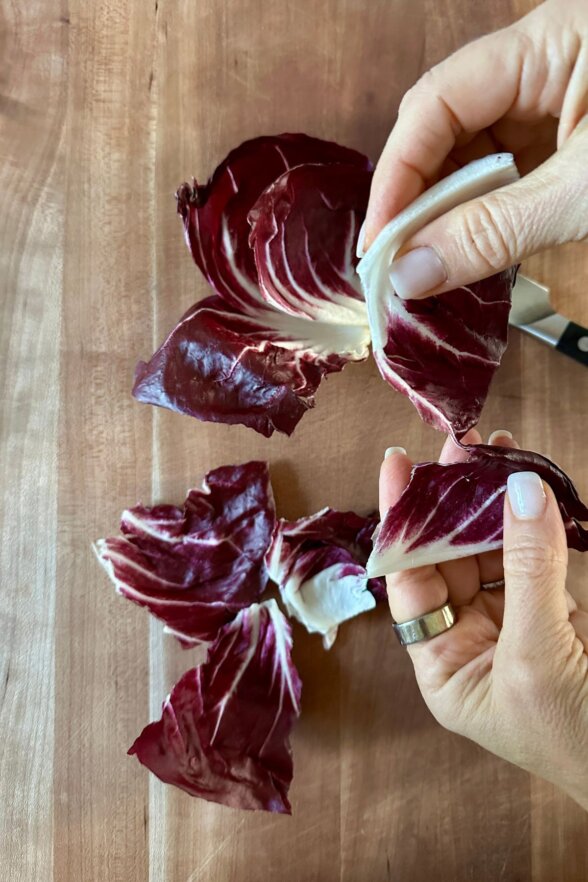 radicchio being torn by hand to go into salad