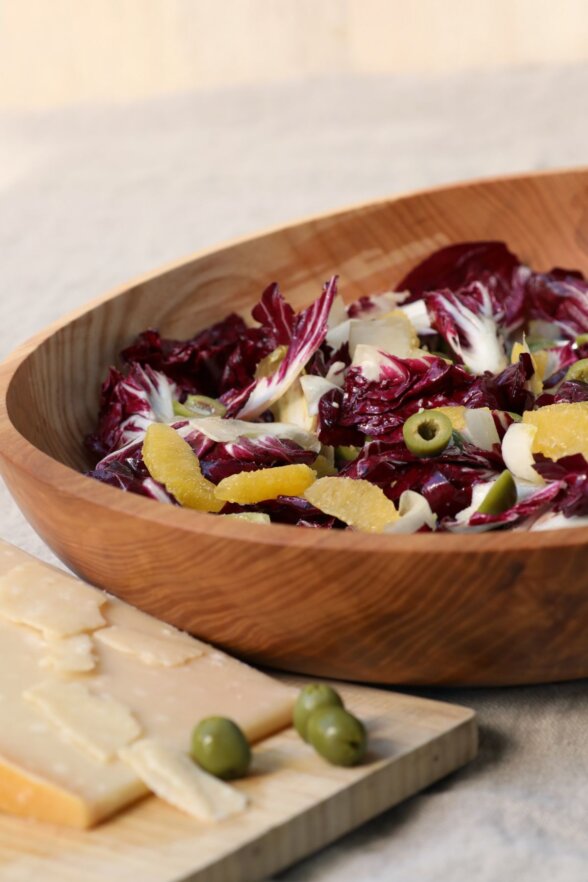 bowl finished with cheese and olives on a wooden cutting board