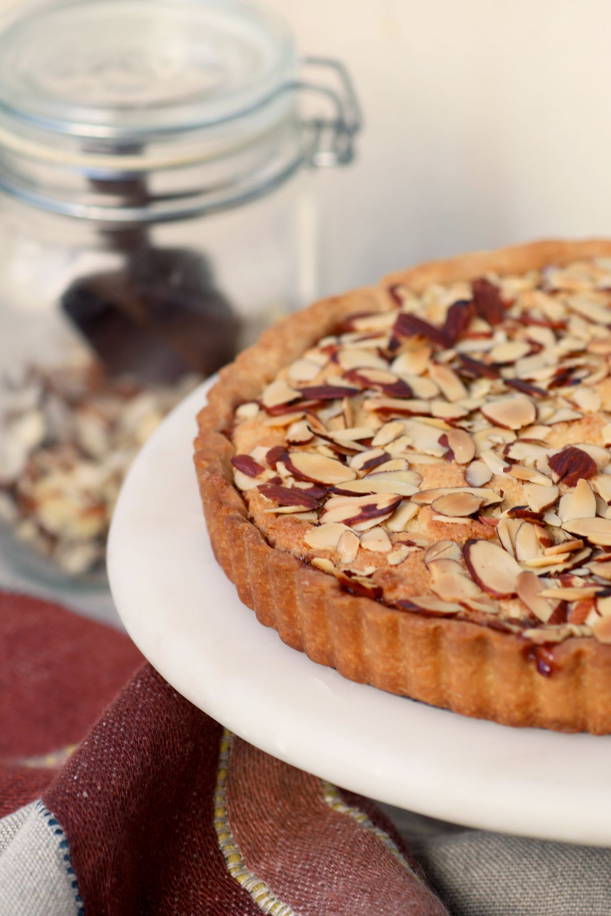 cherry bakewell tart on a cake stand