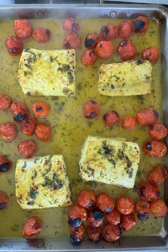 fish and tomatoes on a baking sheet