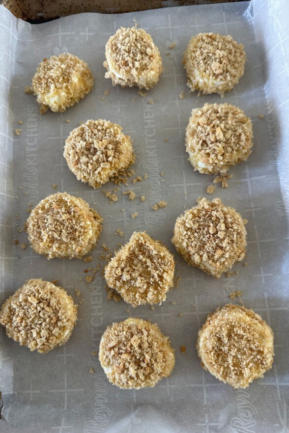 goat cheese coated in breadcrumbs and placed on a baking sheet