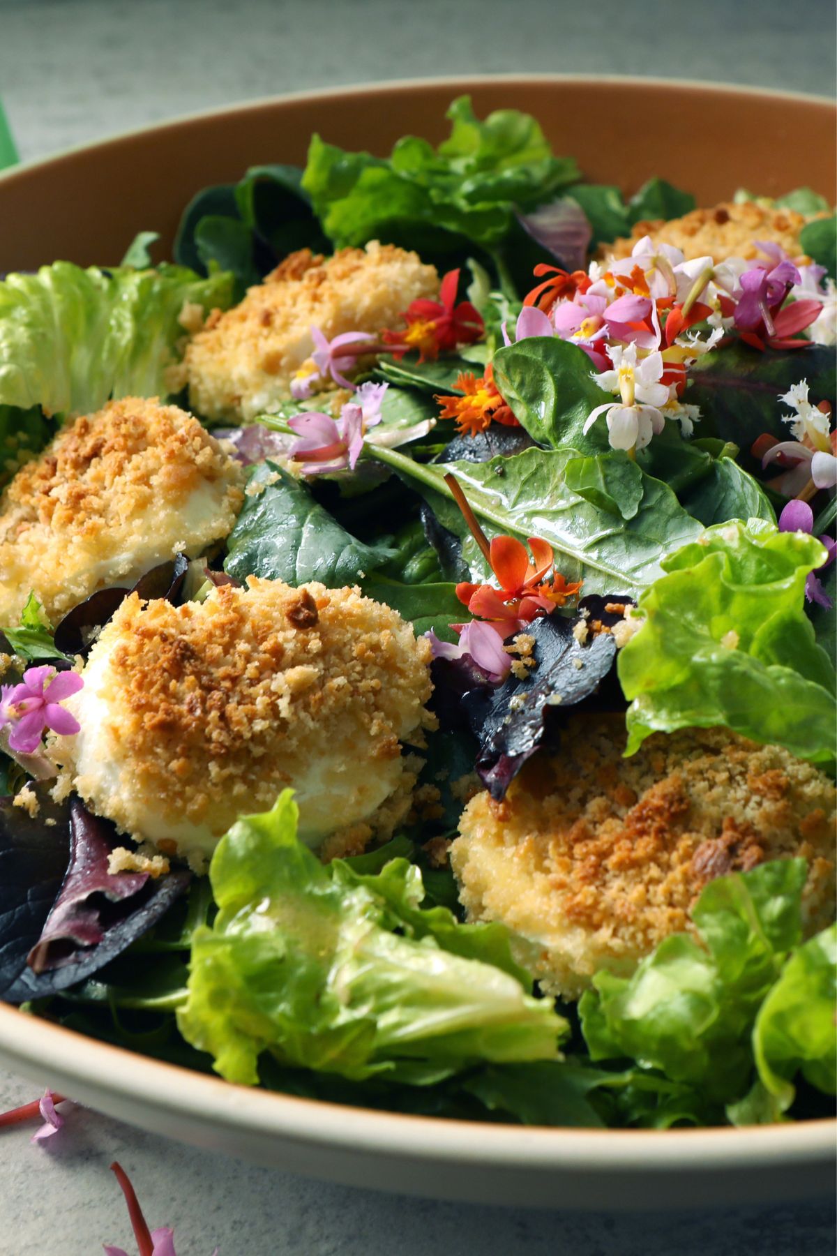 lettuce in a bowl topped with goat cheese