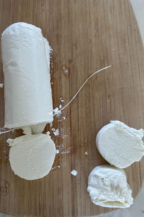 goat cheese and dental floss on a cutting board