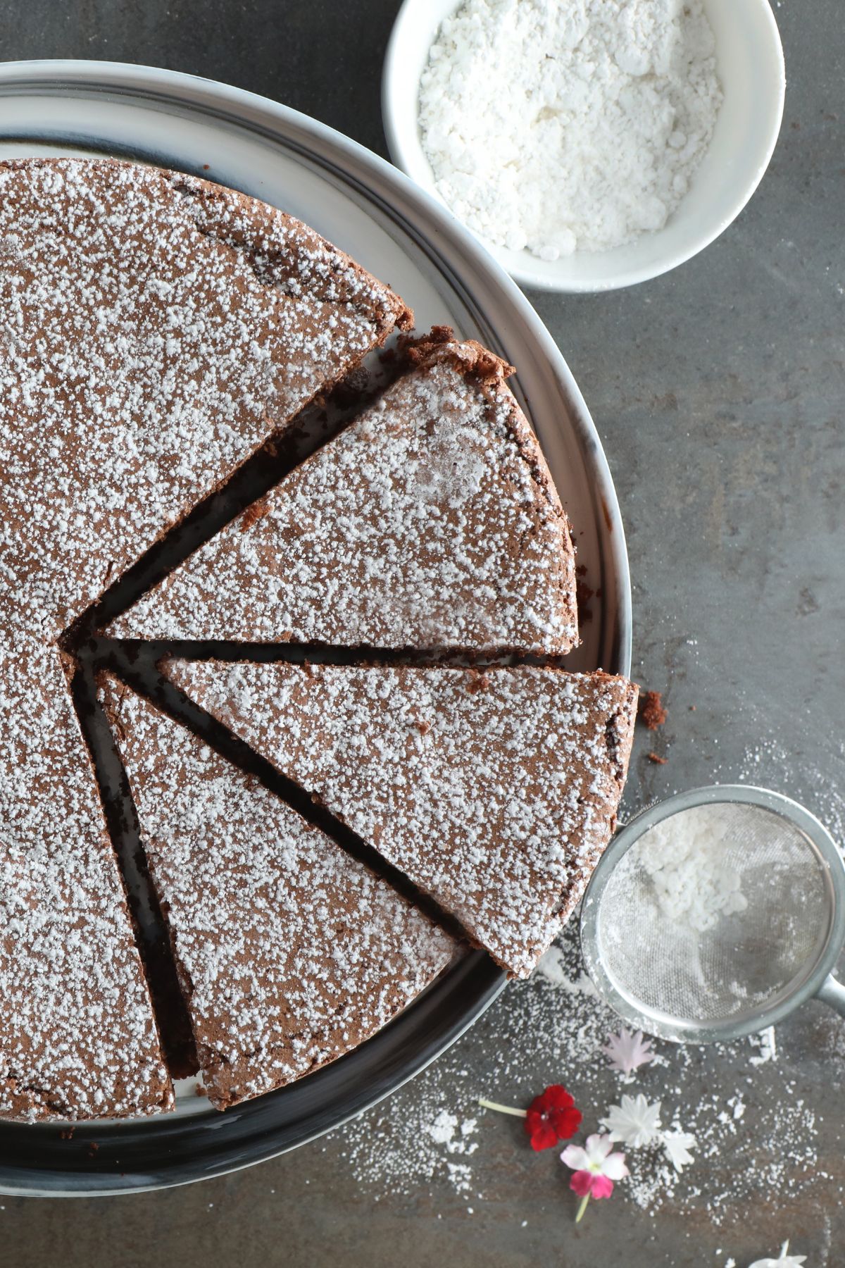 a sliced torta caprese dusted with powdered sugar