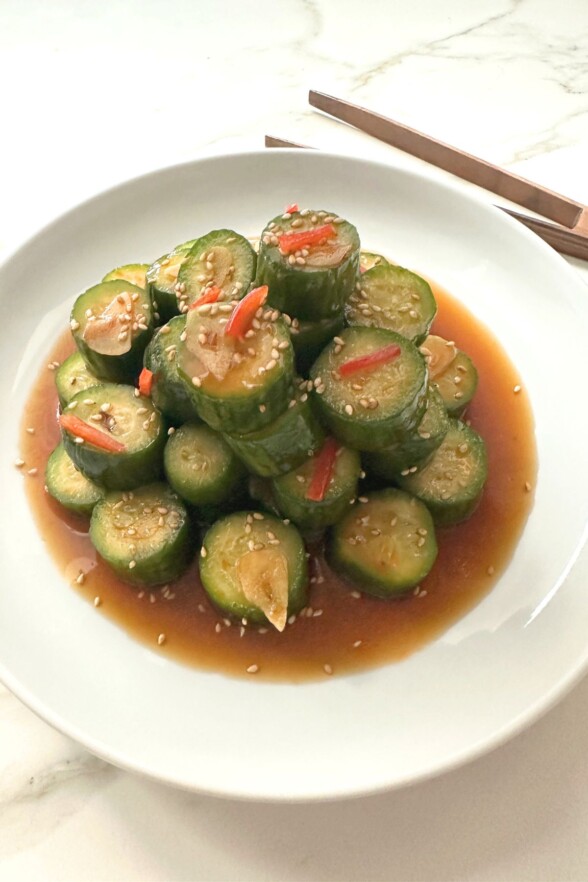 Final plated spicy cucumber salad garnished with red pepper slices and sesame seeds.