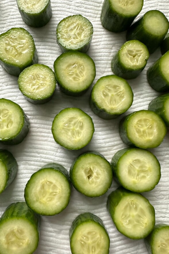 sliced cucumbers drying on a paper towel. 