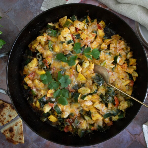 Bowl of Mexican calabacitas with zucchini, corn, and melted cheese