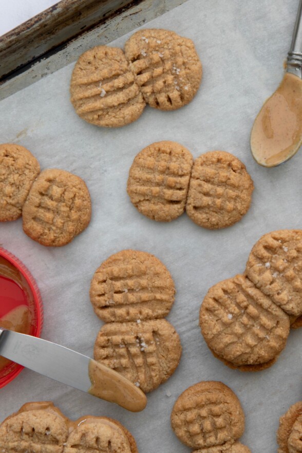 Freshly baked Nutter Butter cookies cooling on parchment paper, golden and crisp