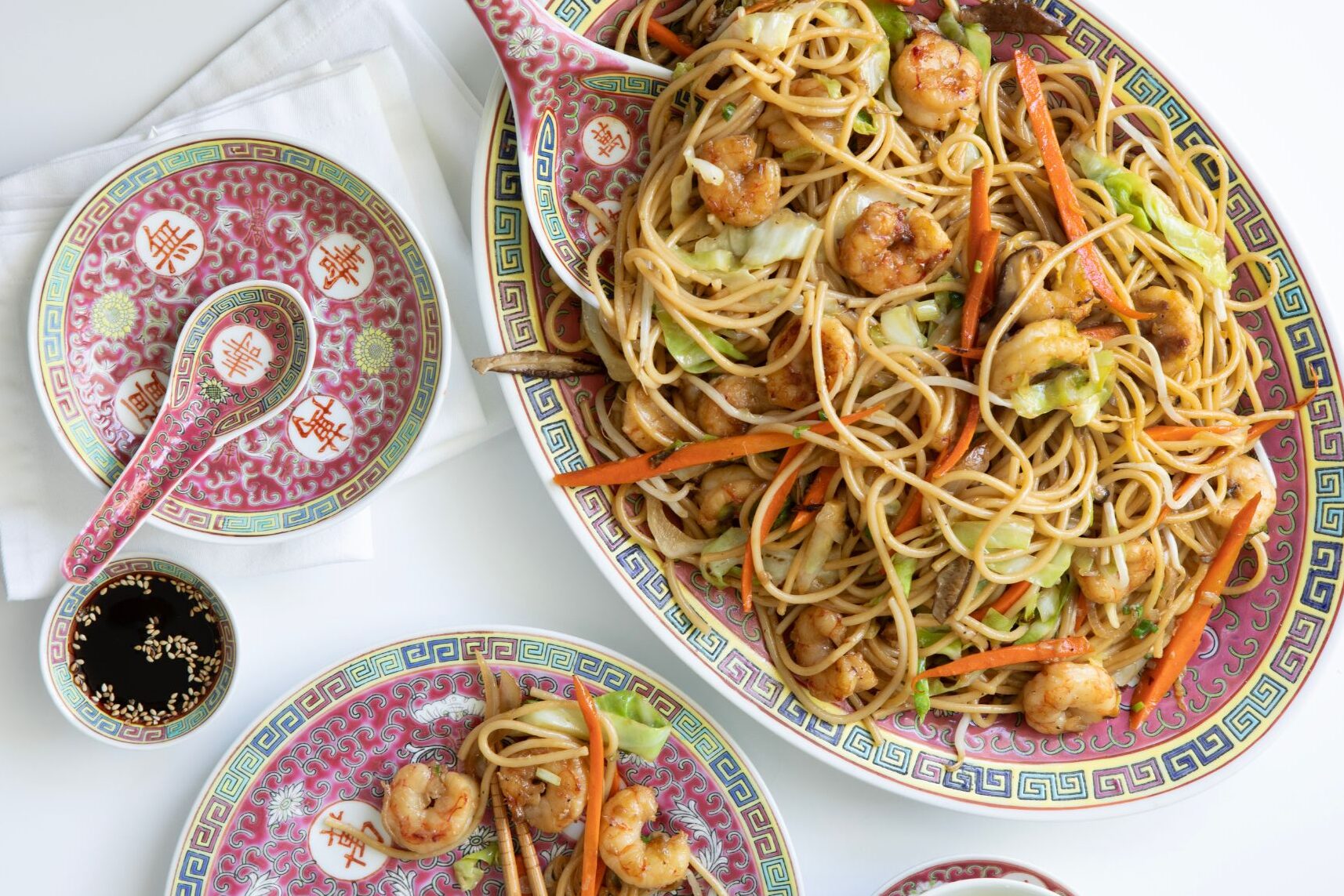 Close-up of a serving of shrimp lo mein in a bowl, highlighting textures and colors