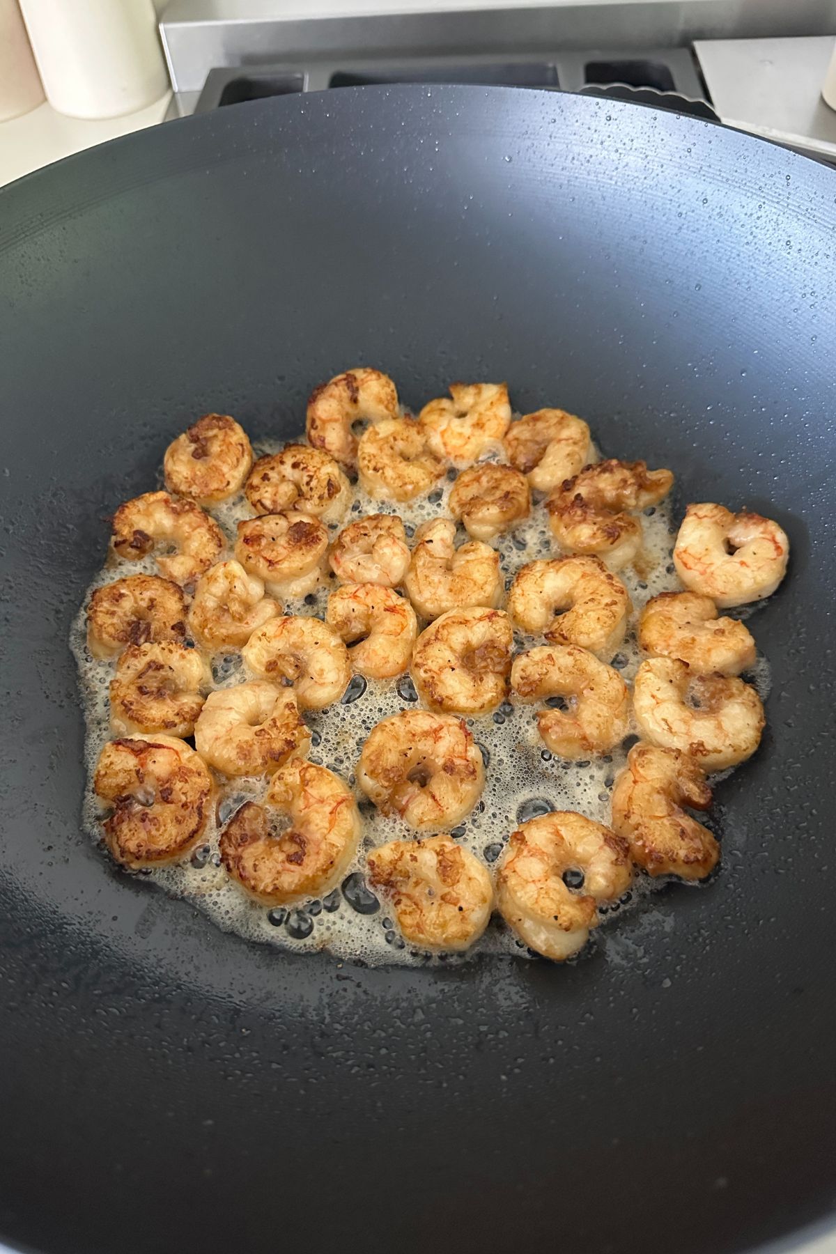 Shrimp seared in a wok, just cooked through and removed from the pan